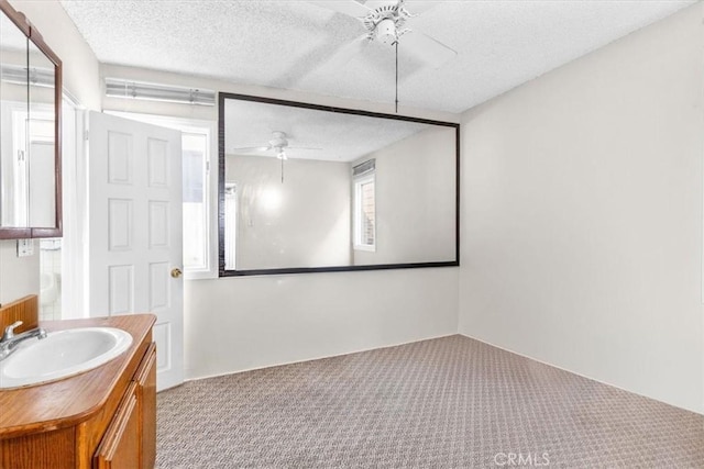 bathroom featuring ceiling fan, a textured ceiling, and vanity