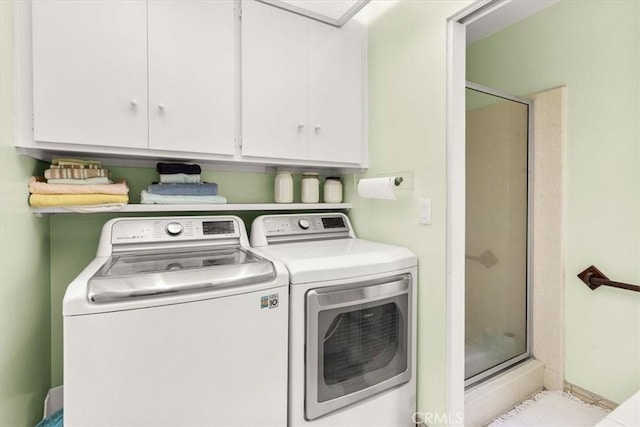 washroom with cabinets and washing machine and dryer