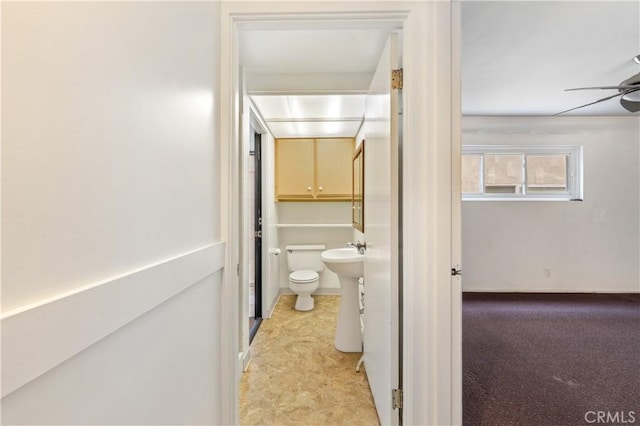 bathroom with ceiling fan, a sink, and toilet