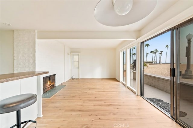 1510 W Oceanfront, Newport Beach, CA 92663 - unfurnished living room with light wood-style floors and a large fireplace