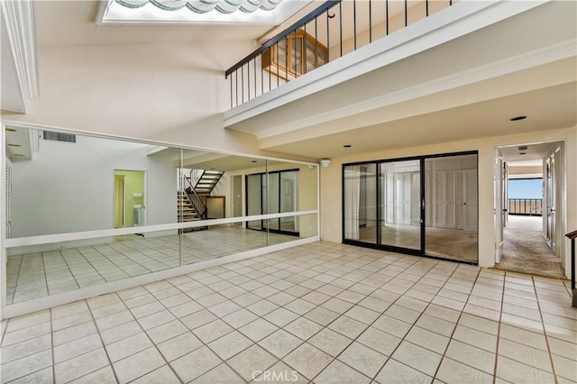 1510 W Oceanfront, Newport Beach, CA 92663 - tiled empty room featuring stairway, baseboards, a high ceiling, and visible vents