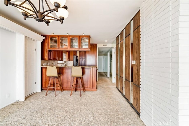 1510 W Oceanfront, Newport Beach, CA 92663 - kitchen featuring freestanding refrigerator, light colored carpet, glass insert cabinets, and an inviting chandelier