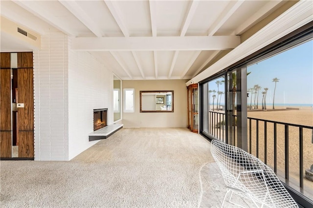 1510 W Oceanfront, Newport Beach, CA 92663 - interior space featuring a large fireplace, lofted ceiling with beams, carpet flooring, and visible vents