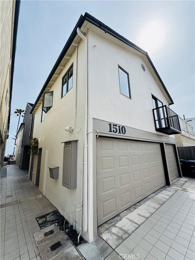1510 W Oceanfront, Newport Beach, CA 92663 - view of home's exterior with stucco siding, a balcony, and an attached garage