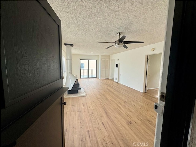 1510 W Oceanfront, Newport Beach, CA 92663 - spare room with a textured ceiling, a wood stove, light wood-style flooring, and ceiling fan