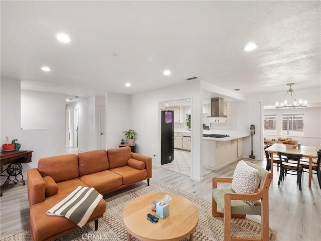 living room with a notable chandelier and light wood-type flooring