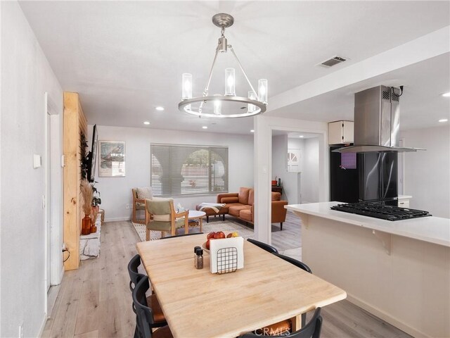 dining area with an inviting chandelier and light hardwood / wood-style floors