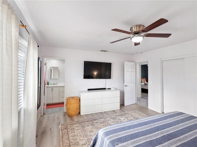 bedroom with ceiling fan, connected bathroom, light wood-type flooring, a closet, and sink