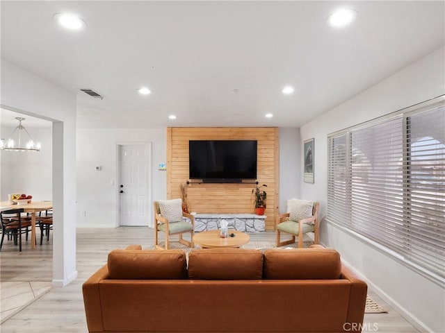 living room with light wood-type flooring and a notable chandelier