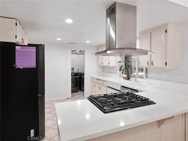 kitchen featuring appliances with stainless steel finishes, island range hood, kitchen peninsula, and sink