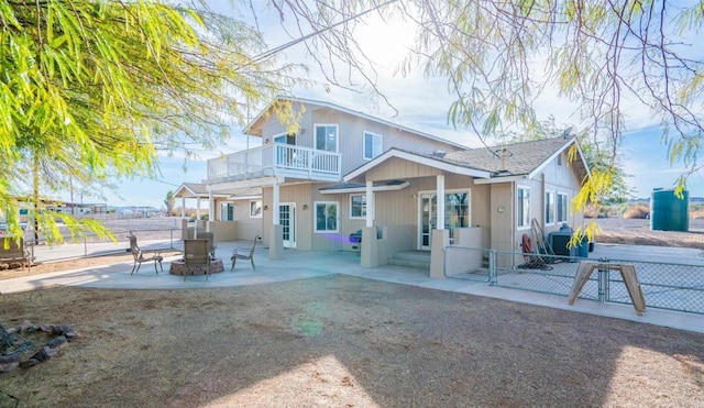 rear view of property with central air condition unit, a fire pit, a balcony, and a patio