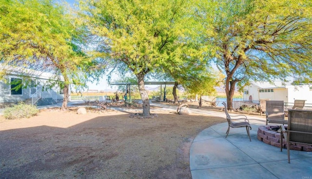 view of yard featuring a fire pit and a patio