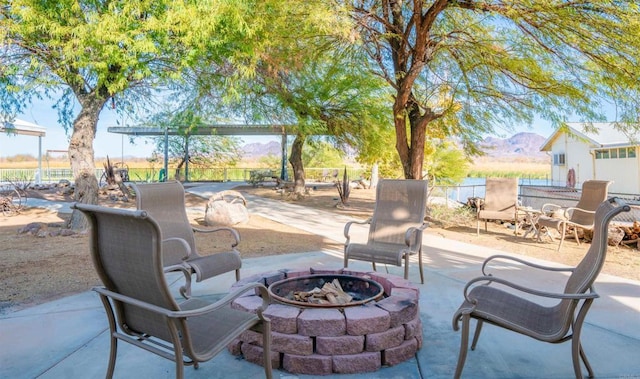 view of patio / terrace featuring a mountain view and a fire pit