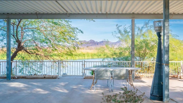 view of patio / terrace with a water and mountain view