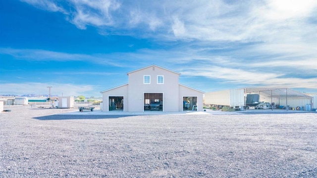 rear view of property with an outdoor structure