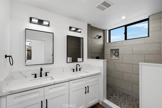 bathroom with vanity and tiled shower