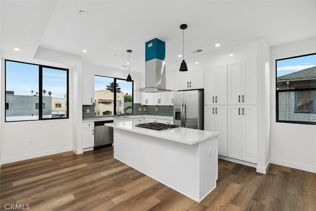 kitchen with white cabinets, a center island, stainless steel appliances, hanging light fixtures, and dark hardwood / wood-style floors