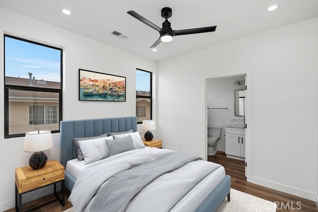 bedroom with dark wood-type flooring, ceiling fan, and ensuite bathroom