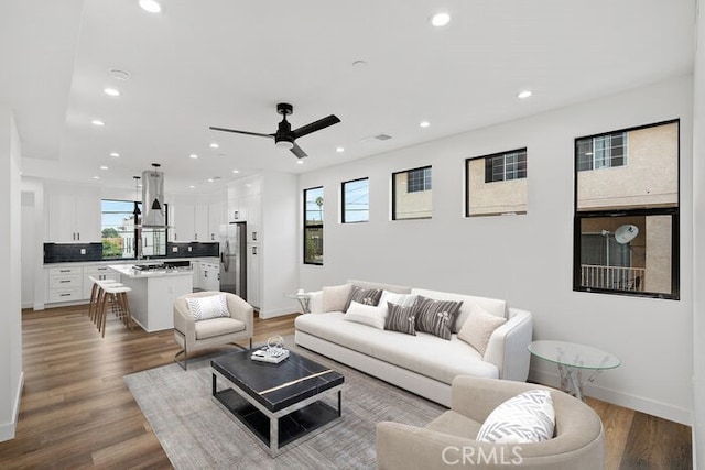 living room with ceiling fan, a wealth of natural light, and hardwood / wood-style flooring