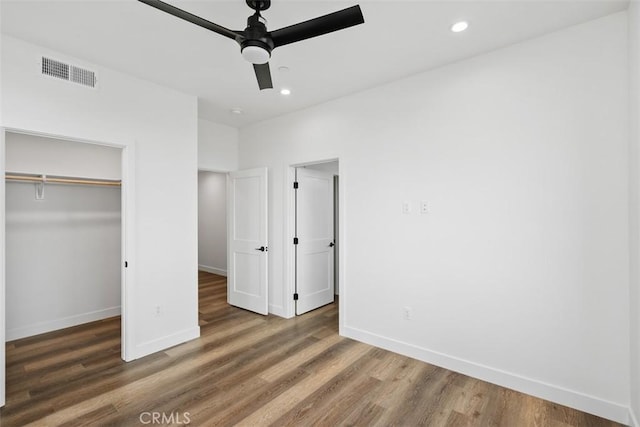 unfurnished bedroom featuring ceiling fan, a closet, and dark hardwood / wood-style flooring