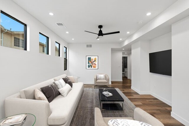 living room with dark wood-type flooring and ceiling fan