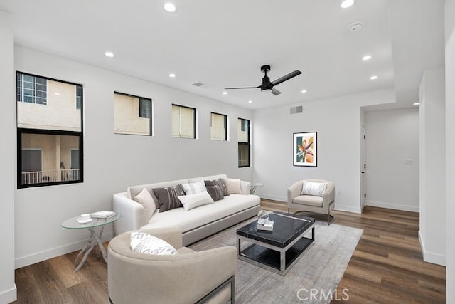 living room featuring ceiling fan and dark hardwood / wood-style flooring