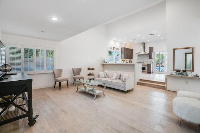 living room with recessed lighting, baseboards, and light wood finished floors