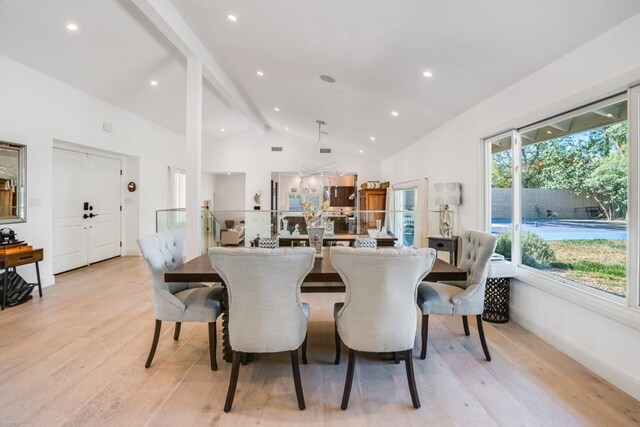 dining room featuring light hardwood / wood-style flooring and lofted ceiling with beams