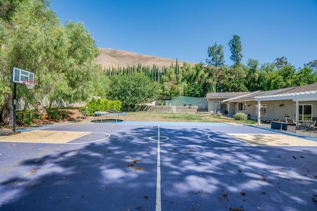 view of basketball court with community basketball court and a trampoline