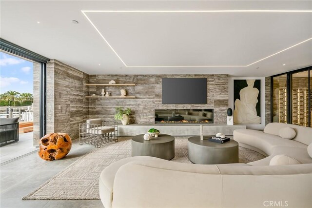 living room featuring a large fireplace and floor to ceiling windows