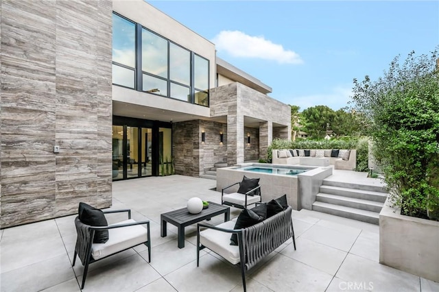 view of patio featuring outdoor lounge area and an in ground hot tub