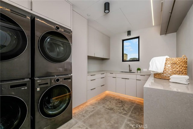 laundry area featuring stacked washer / drying machine, washing machine and dryer, sink, and cabinets