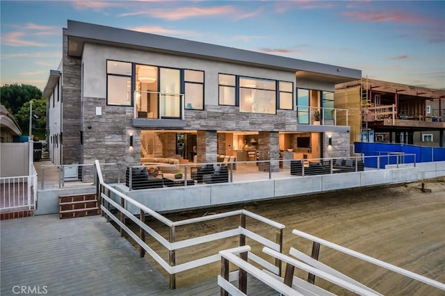 433 Harbor Island Dr, Newport Beach, CA 92660 - back of property at dusk with stone siding and an outdoor living space