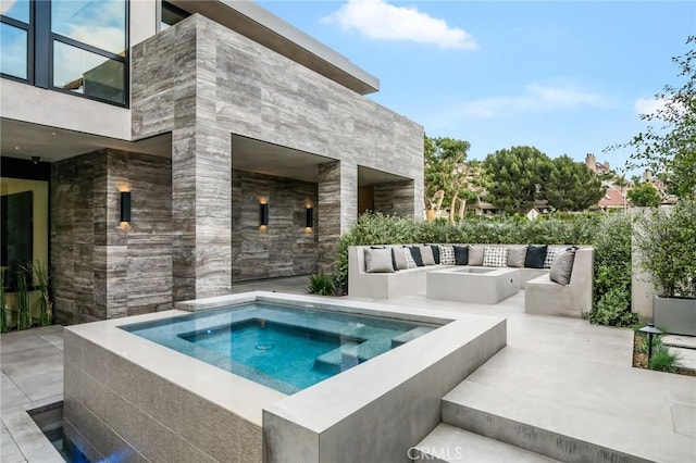 view of pool with an in ground hot tub, an outdoor living space with a fire pit, and a patio