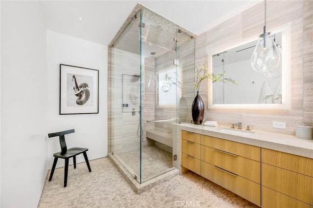 bathroom with a shower with shower door and vanity