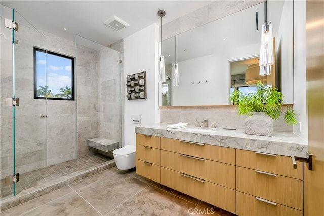 bathroom with toilet, tile patterned floors, vanity, and a shower with shower door