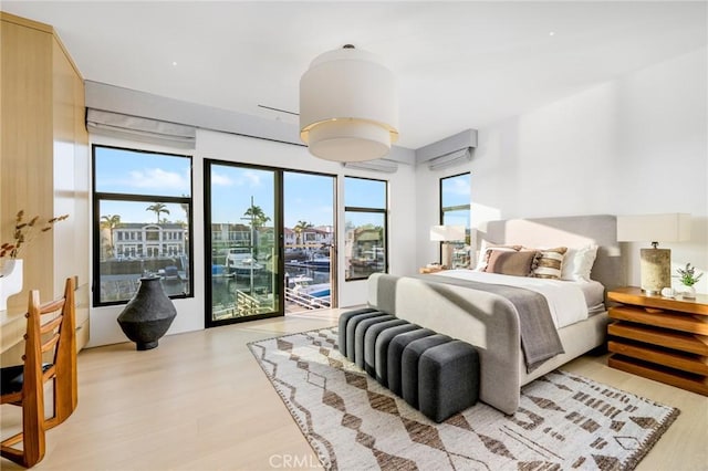 bedroom with access to exterior and light wood-type flooring