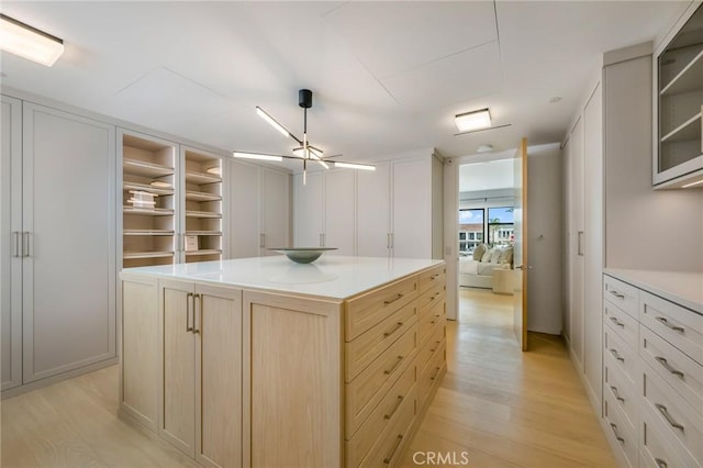 kitchen featuring light wood-type flooring, a kitchen island, and light brown cabinetry