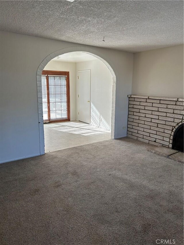 unfurnished room with carpet flooring and a textured ceiling