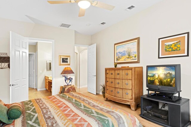 bedroom with ceiling fan, light hardwood / wood-style flooring, and ensuite bath