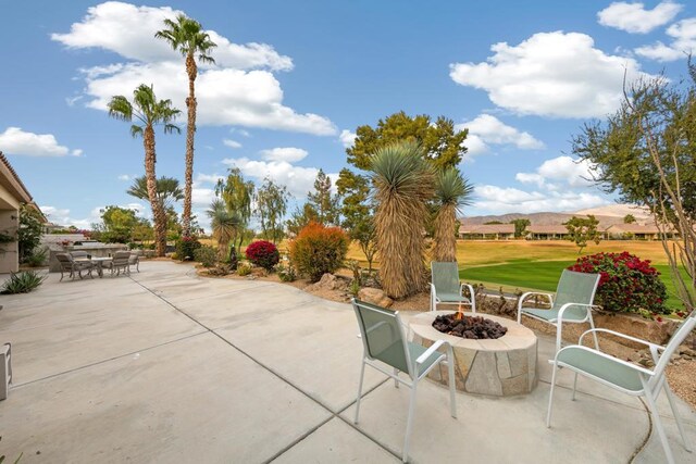 view of patio with an outdoor fire pit and a mountain view