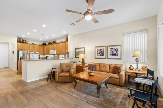 living room with light hardwood / wood-style floors and ceiling fan