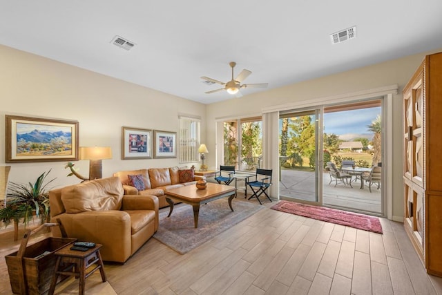 living room featuring ceiling fan and light hardwood / wood-style floors