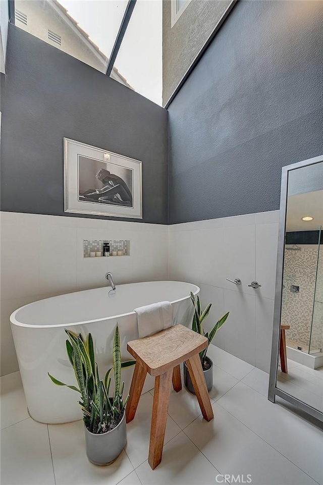 interior space featuring light tile patterned flooring and tile walls