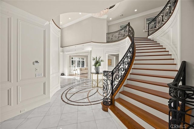 entrance foyer featuring a high ceiling, crown molding, and a chandelier