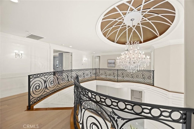 interior space featuring wood-type flooring, crown molding, and a chandelier