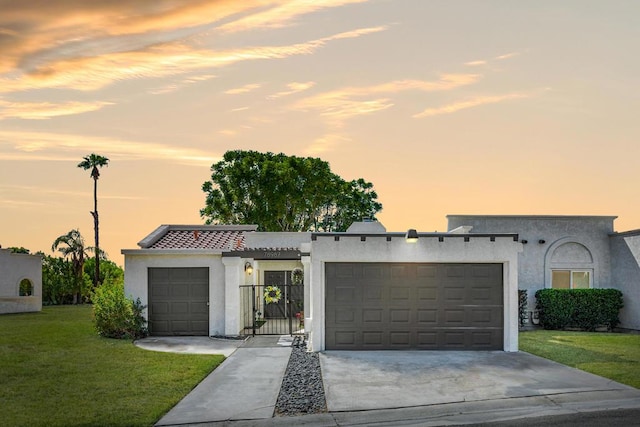 view of front of property featuring a garage and a lawn