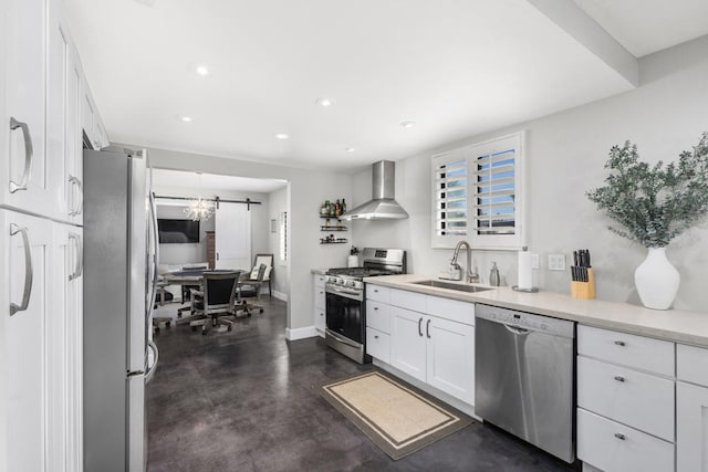 kitchen featuring white cabinetry, wall chimney range hood, stainless steel appliances, and sink