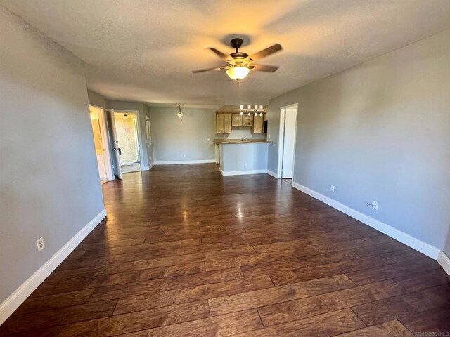 unfurnished living room featuring dark hardwood / wood-style flooring and ceiling fan