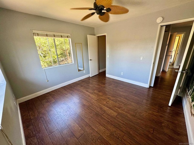 unfurnished bedroom with ceiling fan and dark wood-type flooring